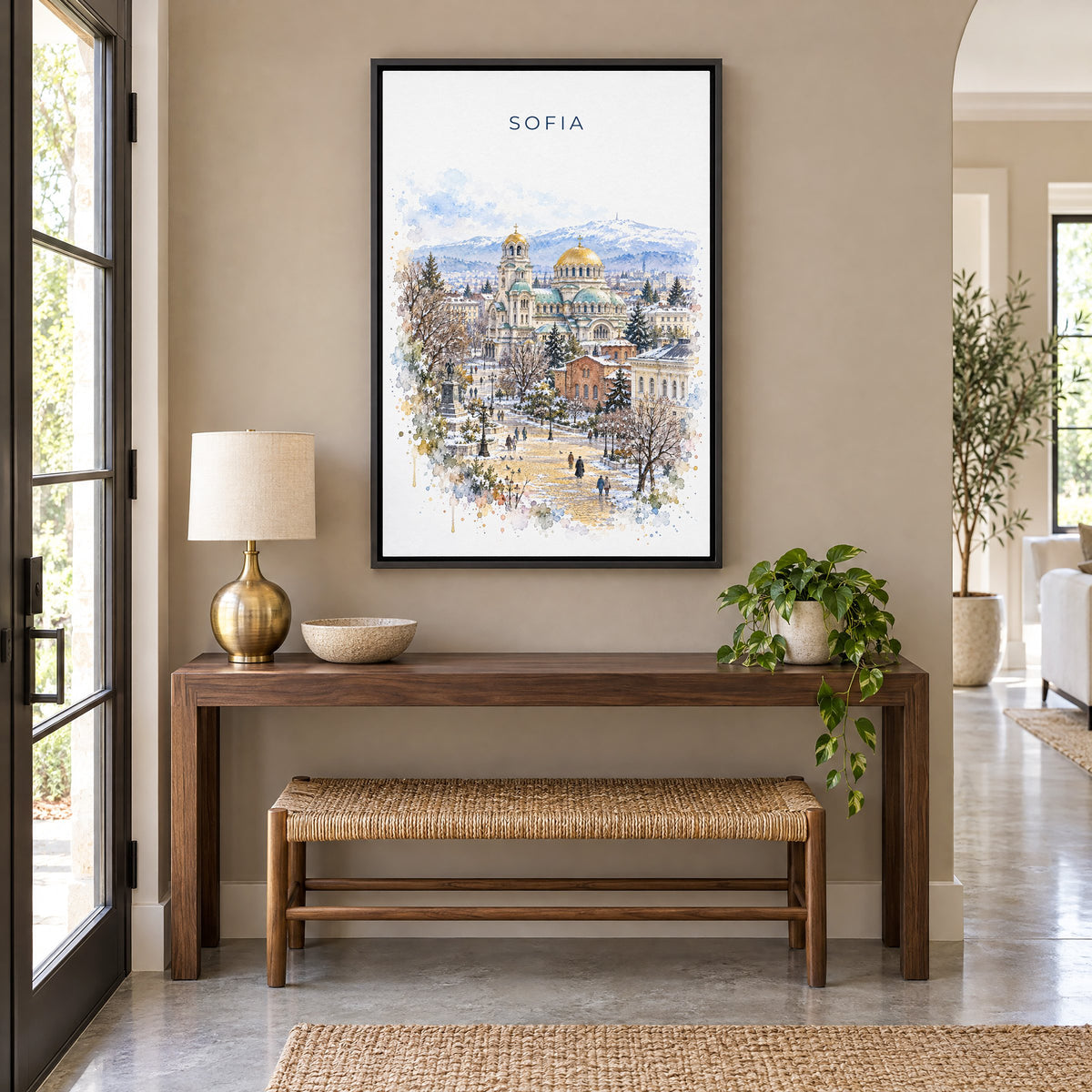 Sofia, Bulgaria watercolor print as a black floater canvas above a walnut console and woven bench in an entryway