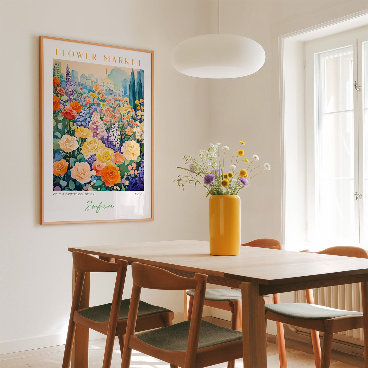Sofia flower market print in an oak frame above a dining table with a yellow vase and white pendant light