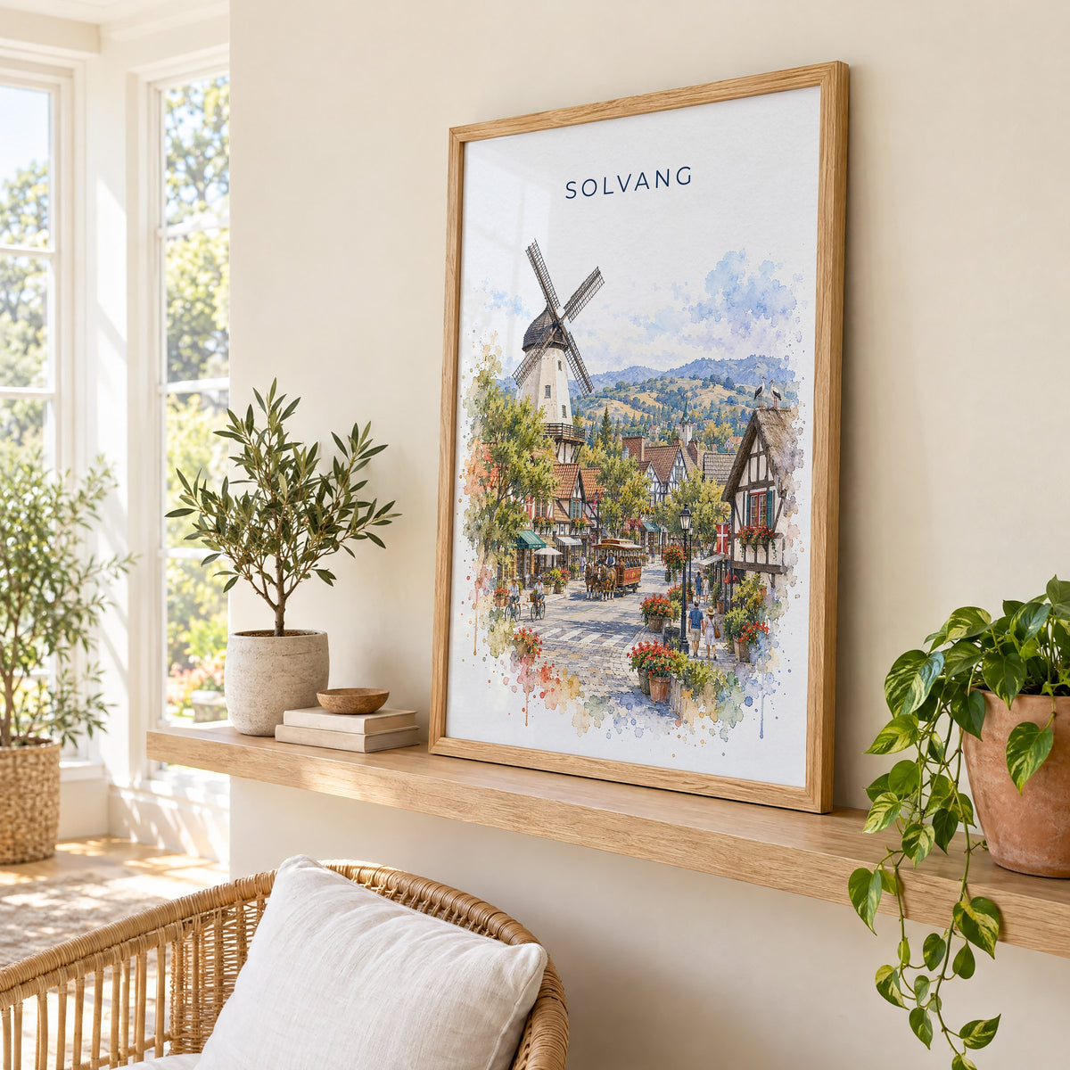 Solvang watercolor print in an oak frame on a picture ledge in a sunlit sunroom