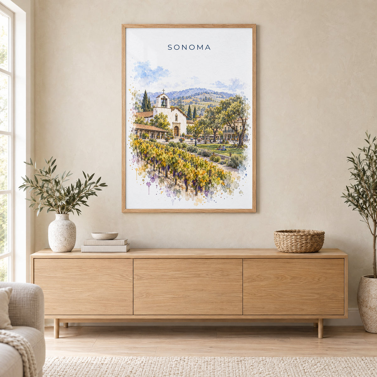 Sonoma watercolor print in an oak frame above a light wood sideboard in a Scandinavian living room