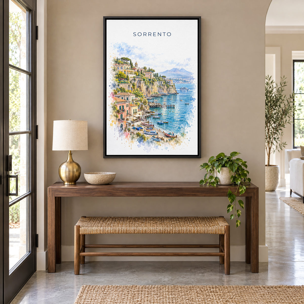 Sorrento watercolor print as a black floater canvas above a walnut console and woven bench in an entryway