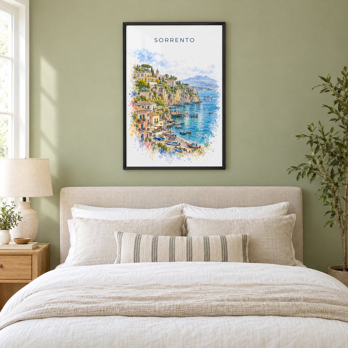 Sorrento watercolor print in a black frame above an upholstered headboard in a sage green bedroom