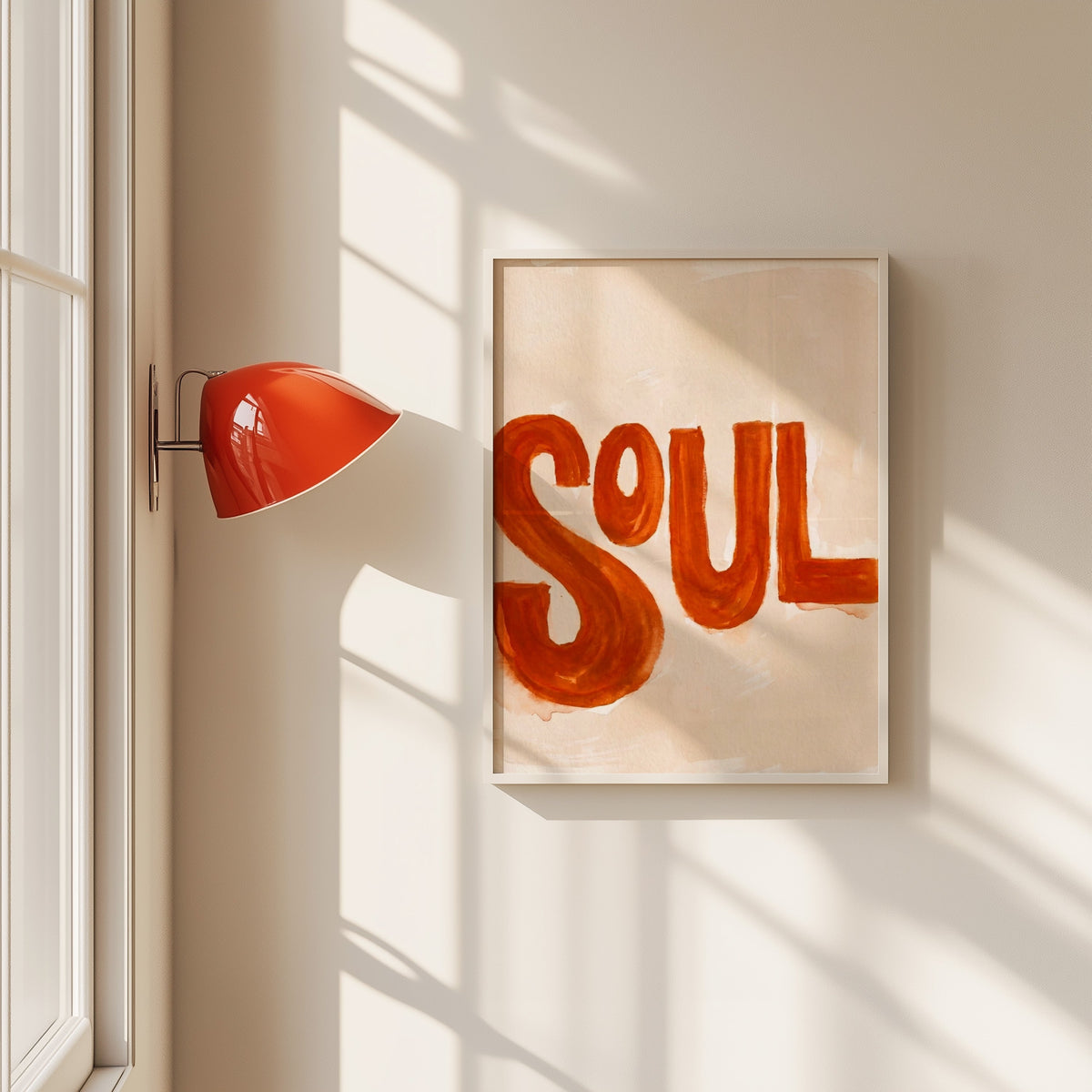 Soul hand lettered print in a white frame beside a red wall sconce