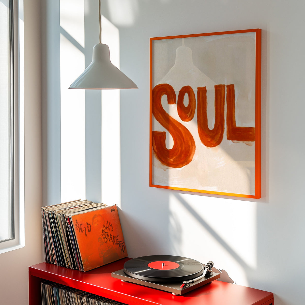 Burnt orange word art print shown in an orange frame above a red record cabinet and turntable