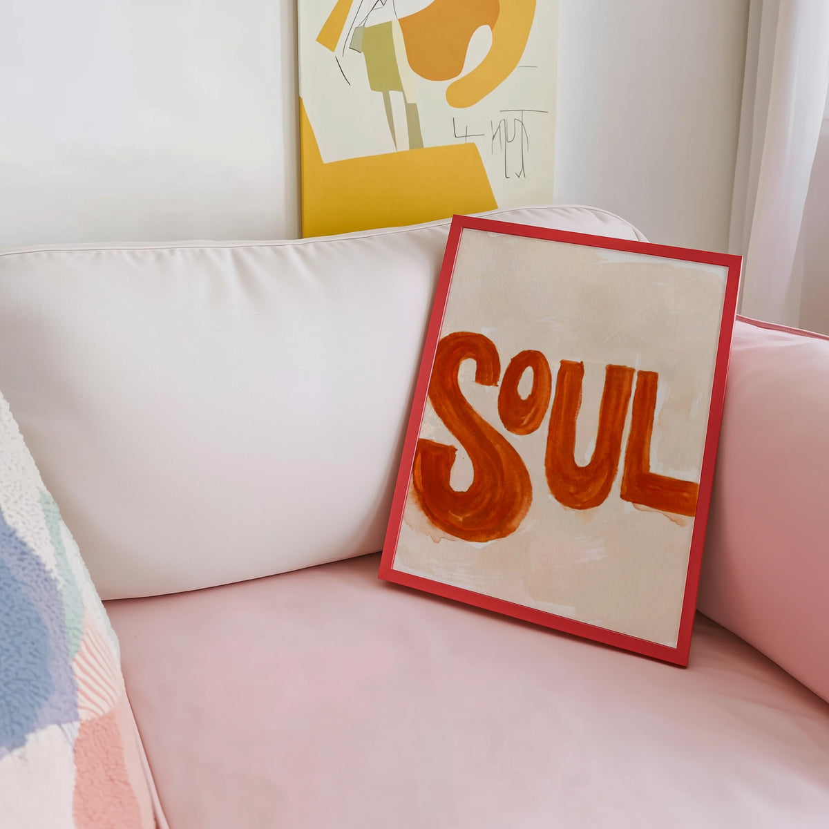 Retro music typography print shown in a red frame leaning on a blush pink sofa