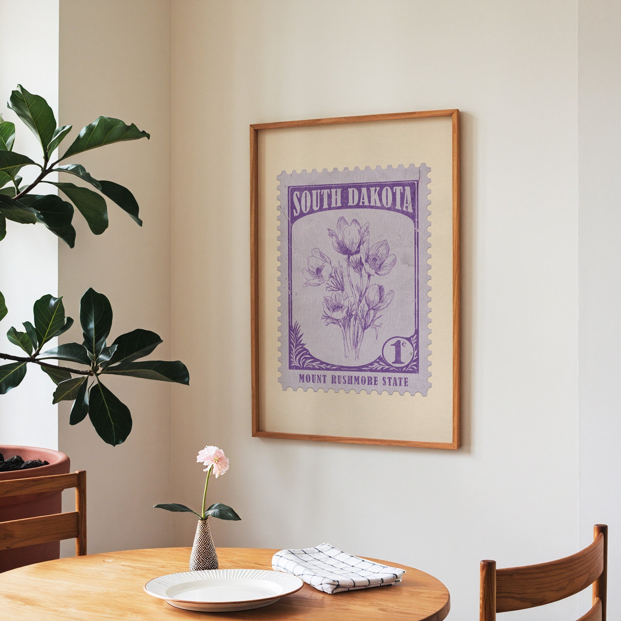 South Dakota state flower print framed above a round wooden table with a bloom in a vase and books