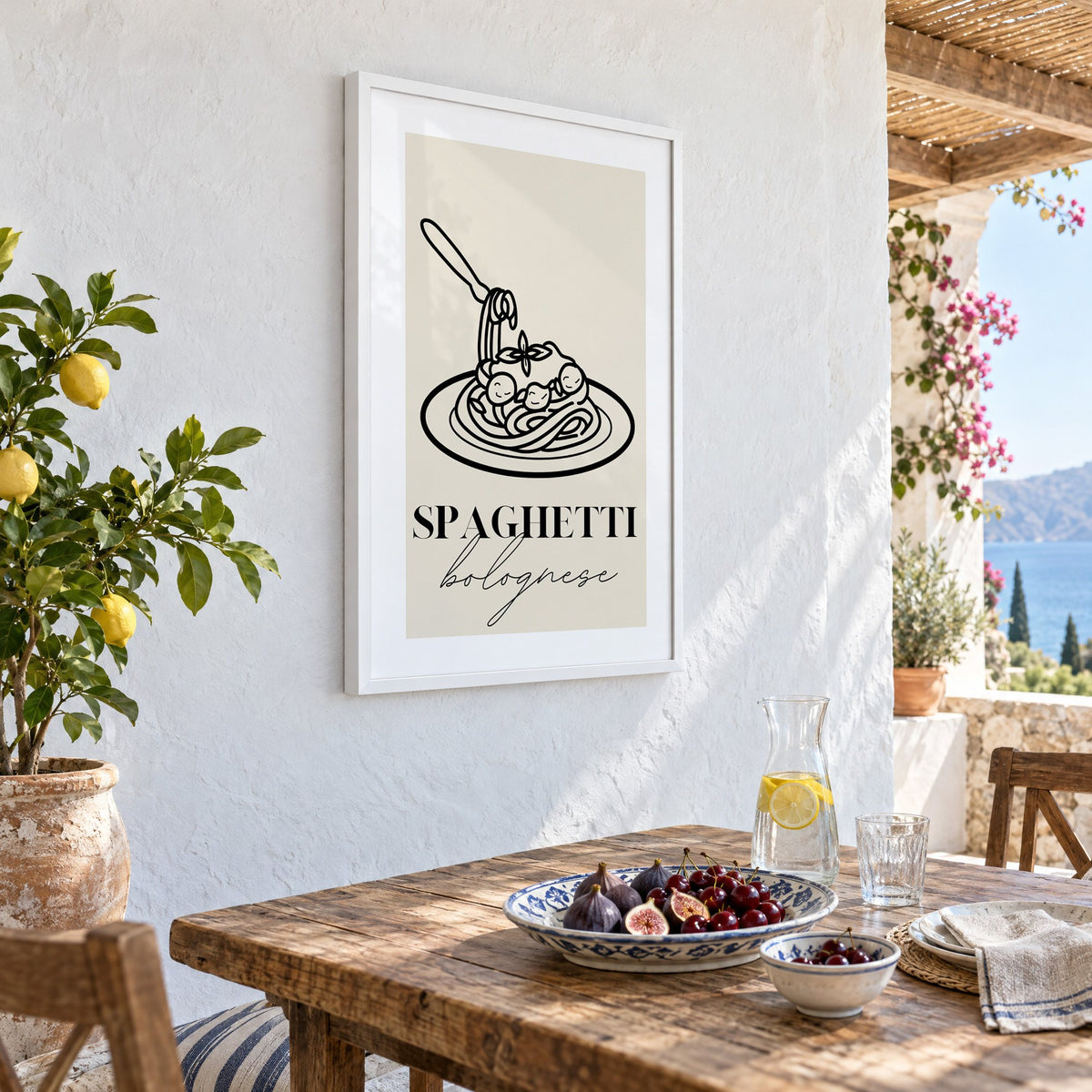 SPAGHETTI bolognese black line meatballs print in a white frame on a whitewashed terrace wall above a lunch table with figs and cherries, seen at an angle