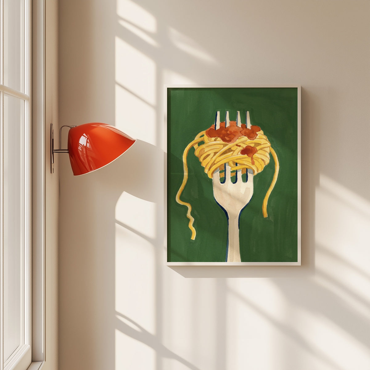 Spaghetti on a fork print in a white frame beside a red wall sconce