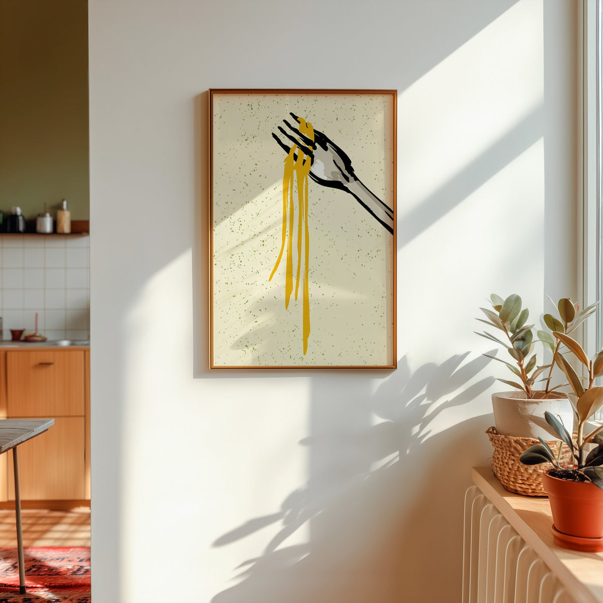 Spaghetti fork print shown in a gold frame in sunlight with plants and a kitchen beyond