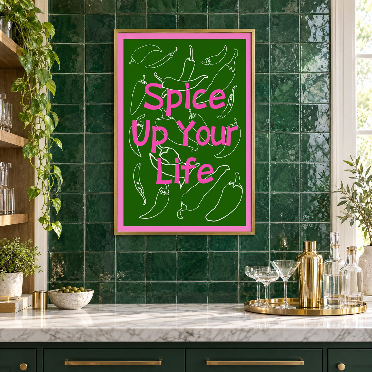 Spice Up Your Life green chilli print in a brass frame on emerald green tiles above a home bar with coupe glasses