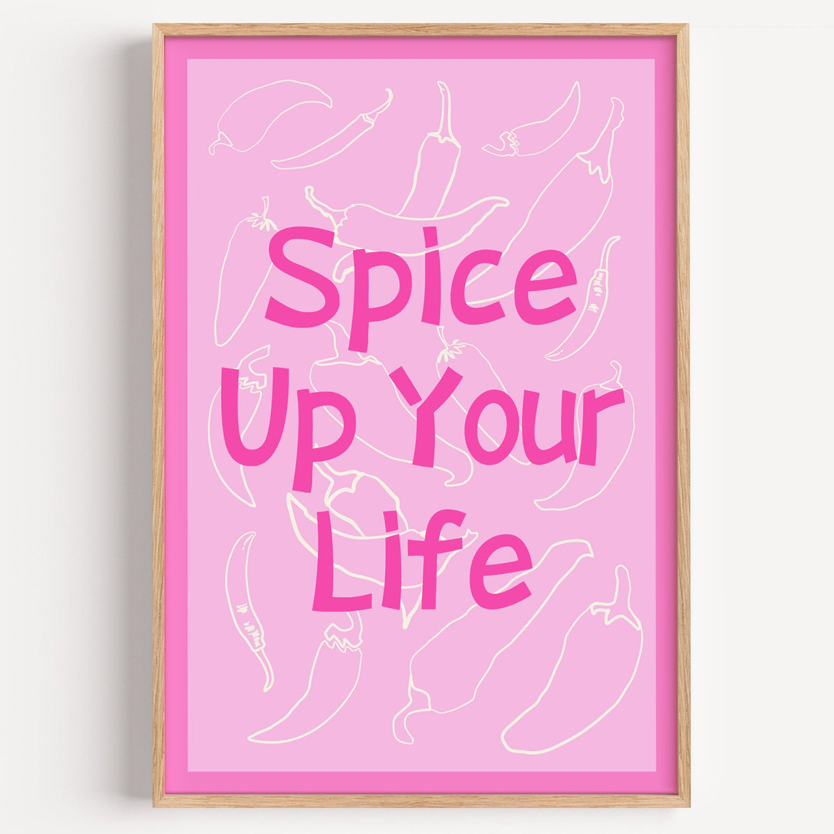 Spice Up Your Life pink chilli print in a light oak frame on a plain white wall