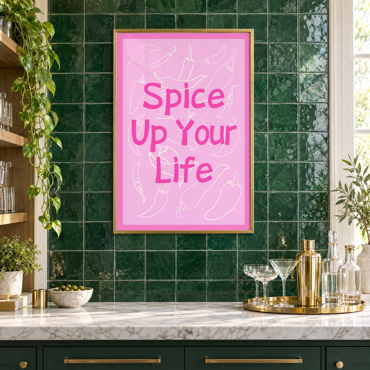 Spice Up Your Life pink chilli print in a brass frame on emerald green tiles above a home bar with coupe glasses