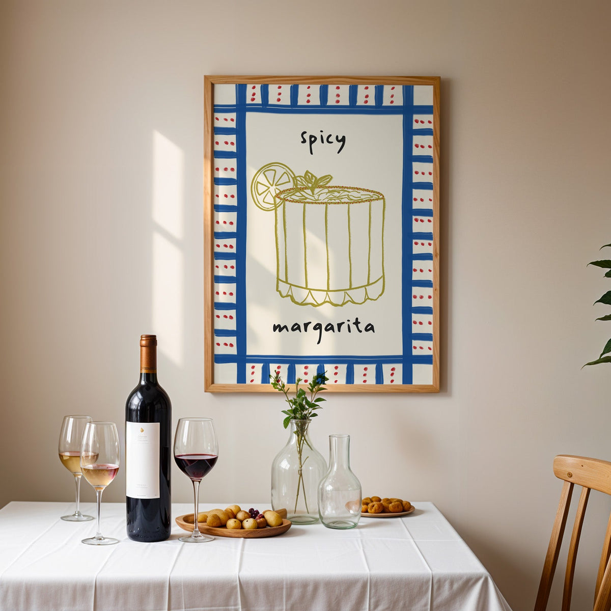 Spicy margarita gingham print in an oak frame above a table laid with red wine