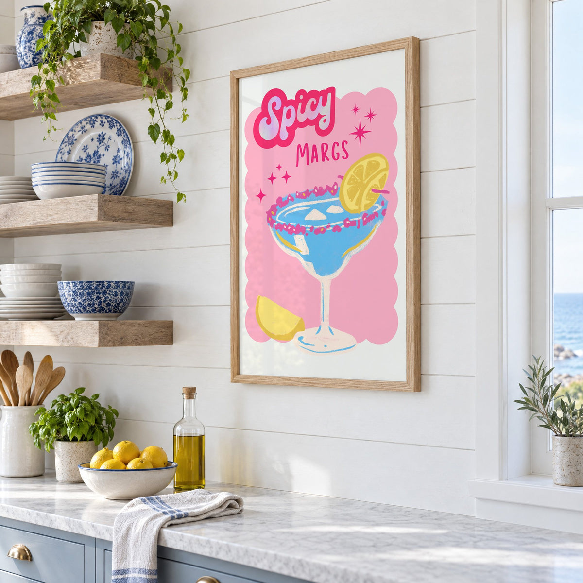 Spicy Margs blue margarita print in an oak frame in a white coastal kitchen beside blue and white plates