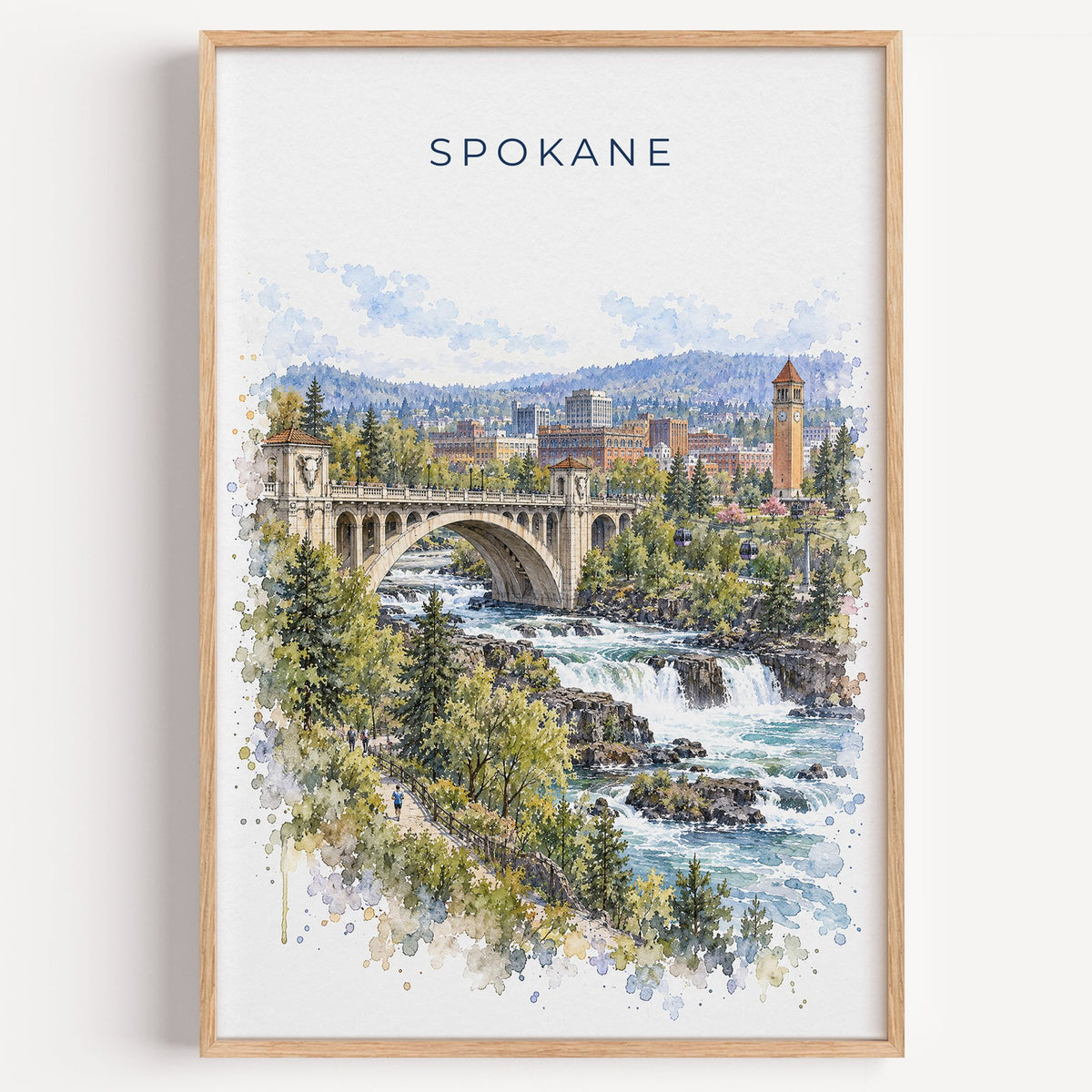 Spokane watercolor print in a light oak frame on a plain white wall