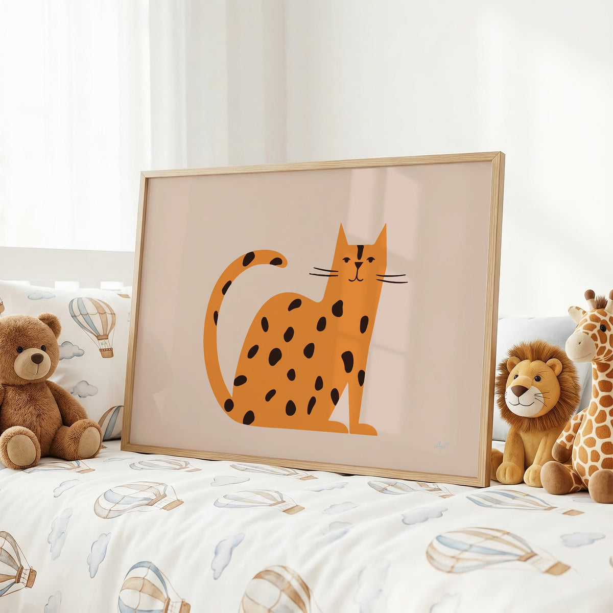 Minimal orange spotted cat nursery print in an oak frame on a kids bed with hot air balloon bedding