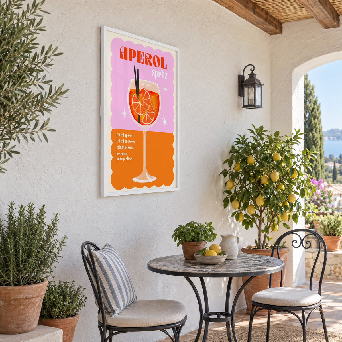 Spritz recipe pink and orange print in a white frame on a sunny patio wall beside a potted lemon tree