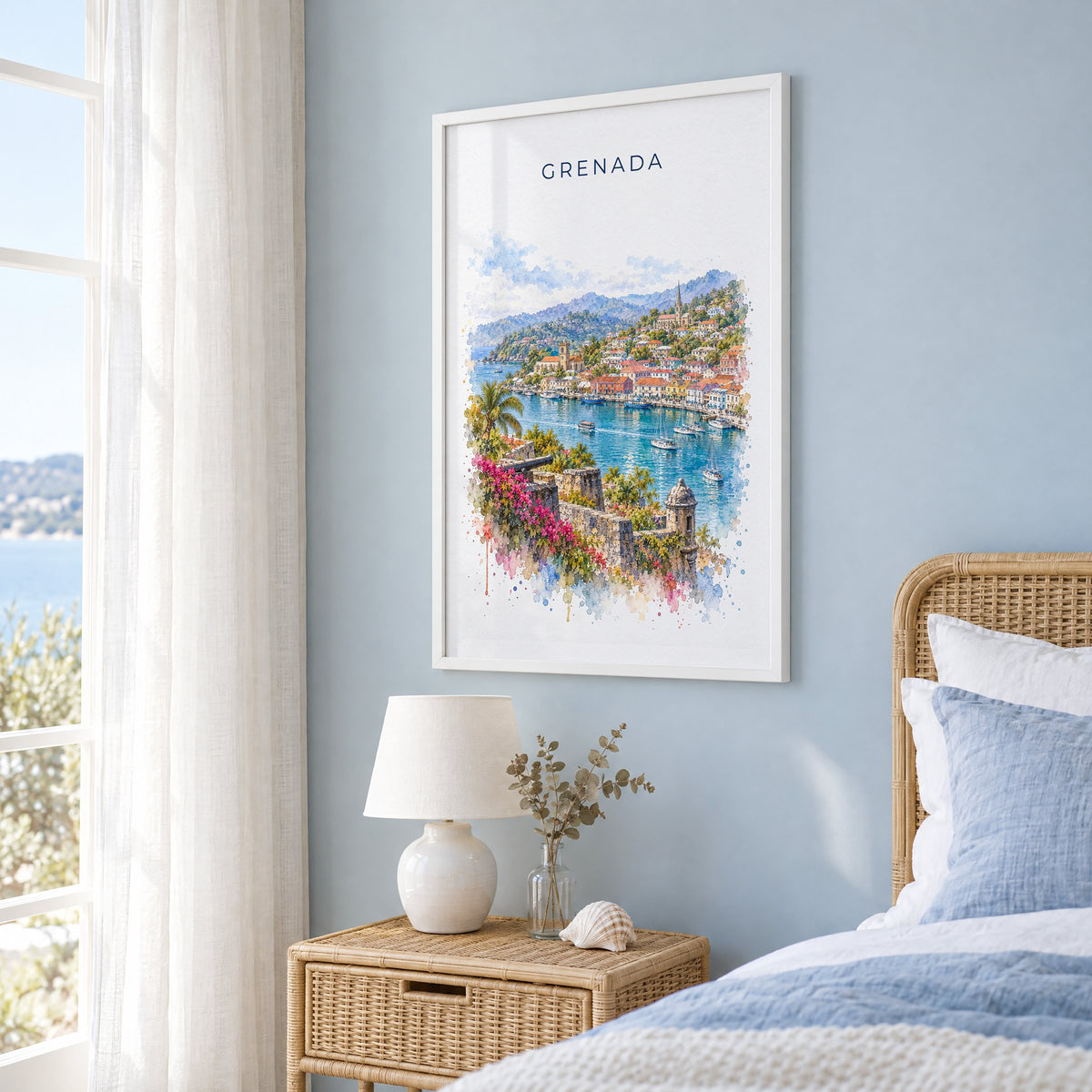 Grenada watercolor print in a white frame on a pale blue wall beside a rattan bed in a coastal bedroom