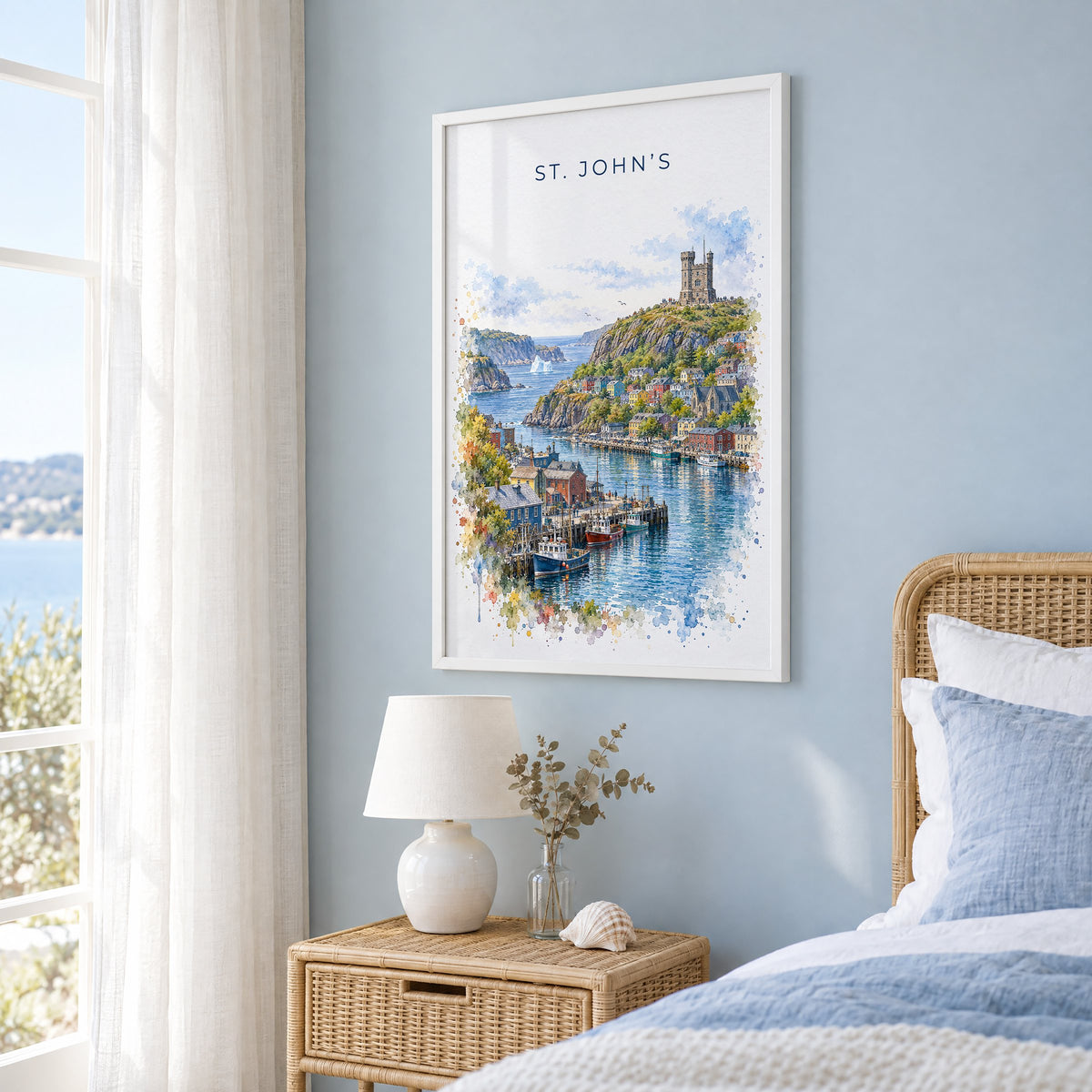 St. John's watercolor print in a white frame on a pale blue wall beside a rattan bed in a coastal bedroom