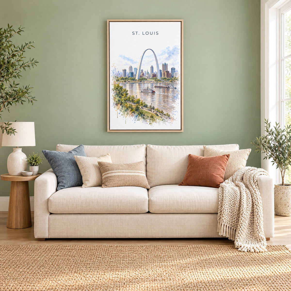 St. Louis watercolor print as a natural floater canvas above a cream linen sofa on a sage green wall