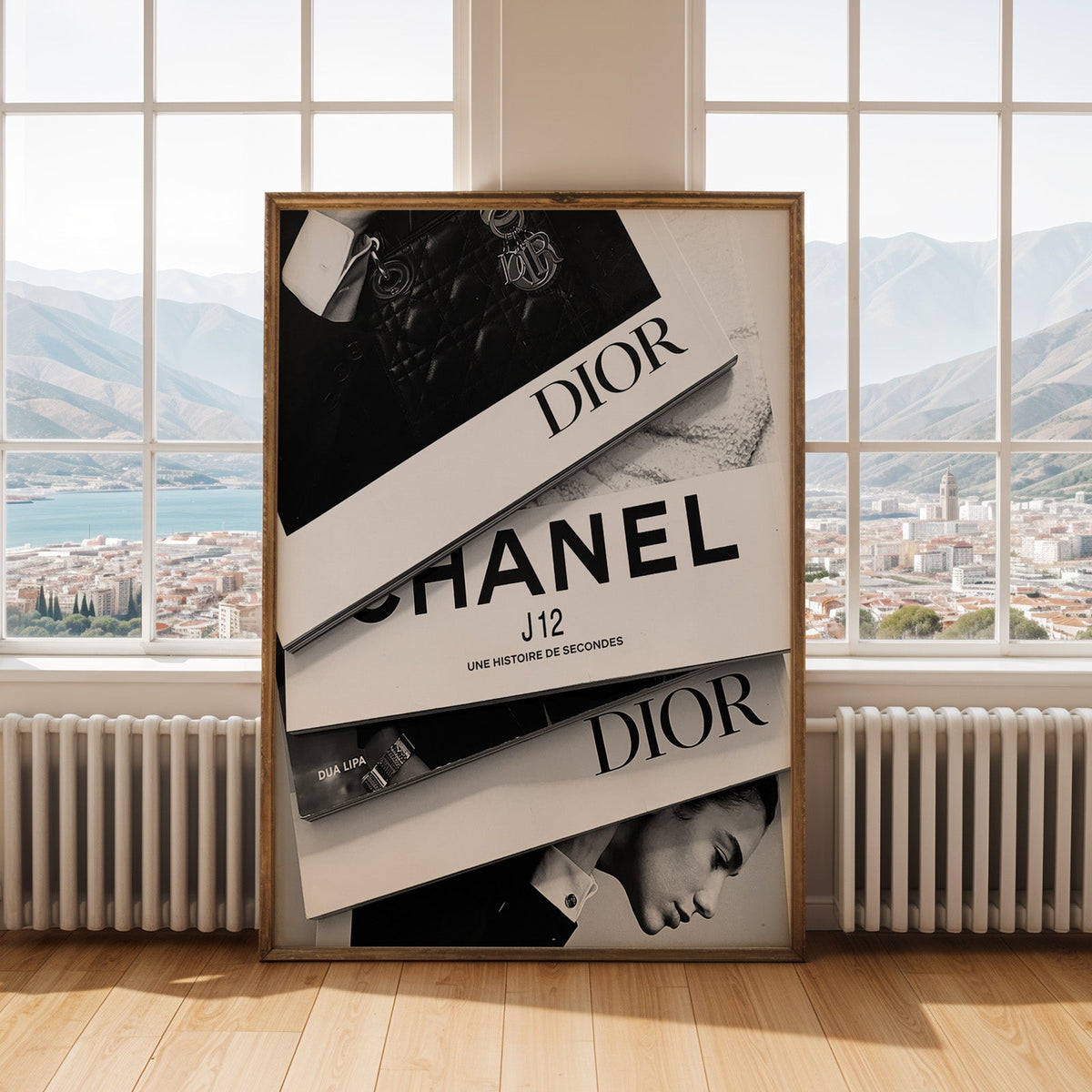 Top-down flat lay of four fashion books print shown in an antique gold frame by tall windows with a sea view