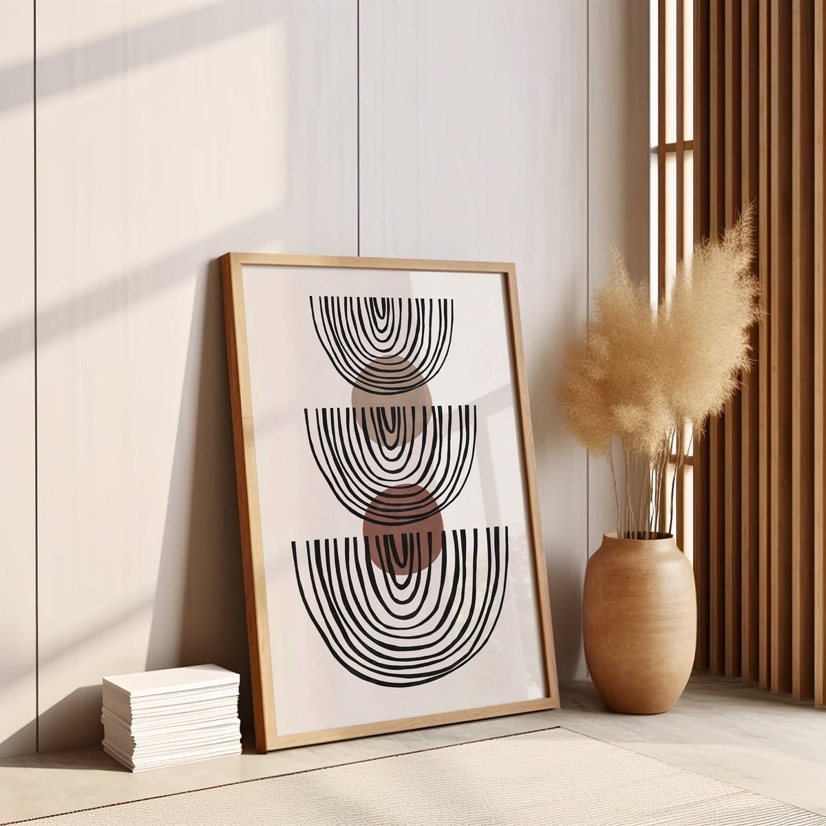 Stacked line bowls and circles boho line art print in an oak frame leaning on the floor by pampas grass and a wood slat screen
