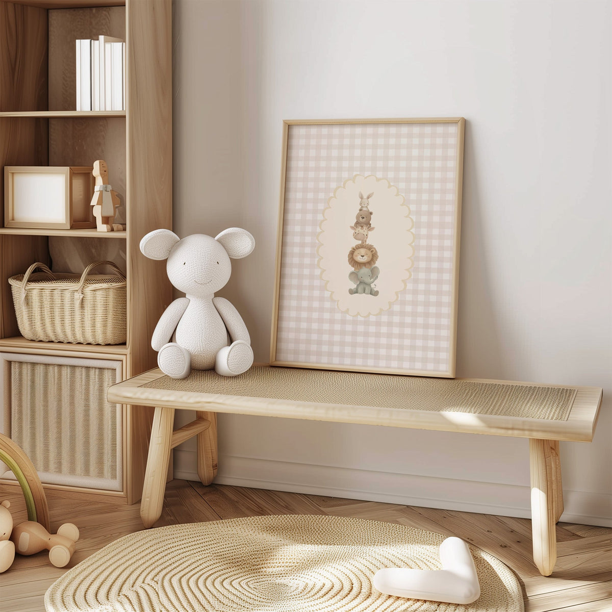 Stacked baby animals in oval on gingham nursery print in an oak frame on a cane bench beside a white knit plush
