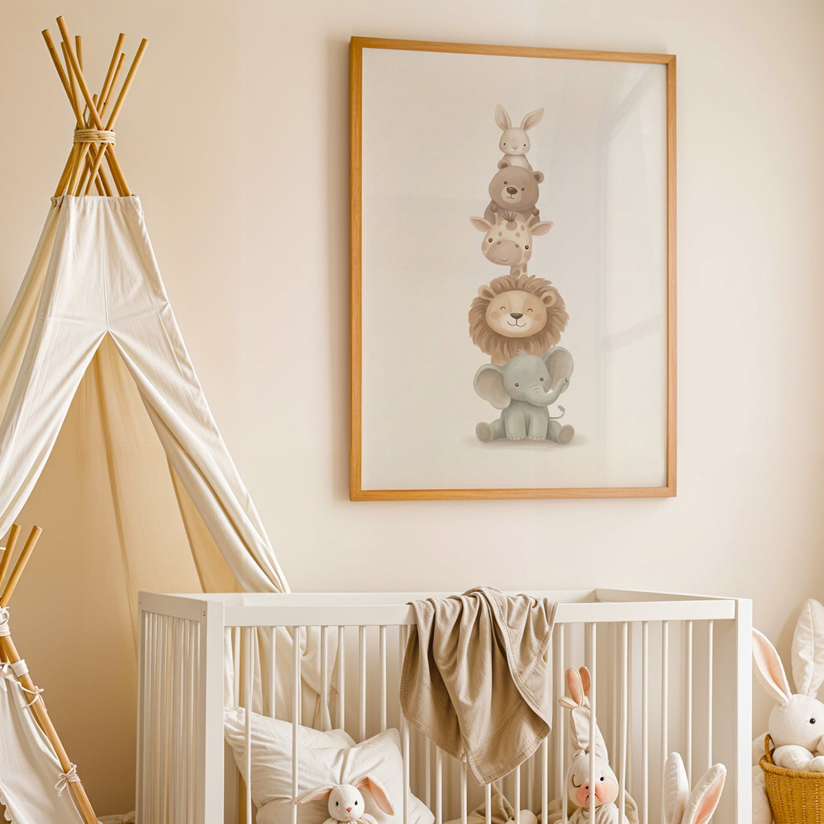 Five baby animals stacked in a tower nursery print in an oak frame above a white crib beside a canvas teepee