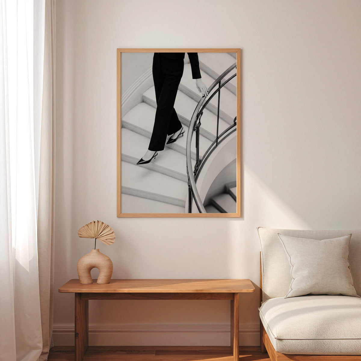 Black trousers and slingback heels on curved stairs print in an oak frame above a narrow console with an arched vase