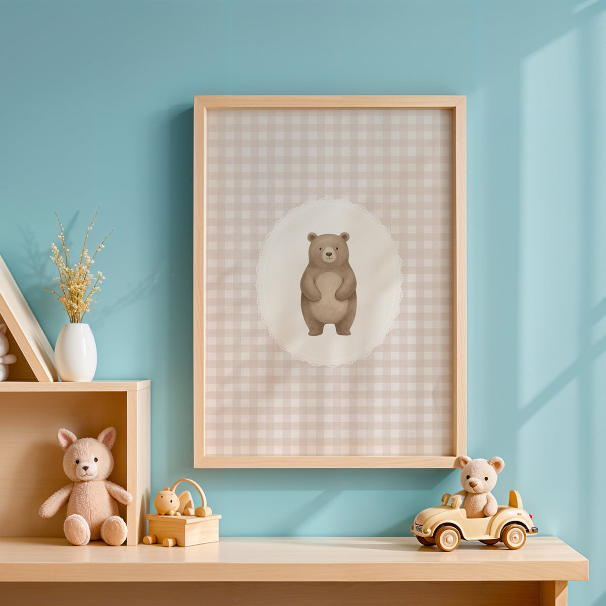 Standing bear in a lace oval on beige gingham nursery print in an oak frame on a blue wall above a shelf of wooden toys