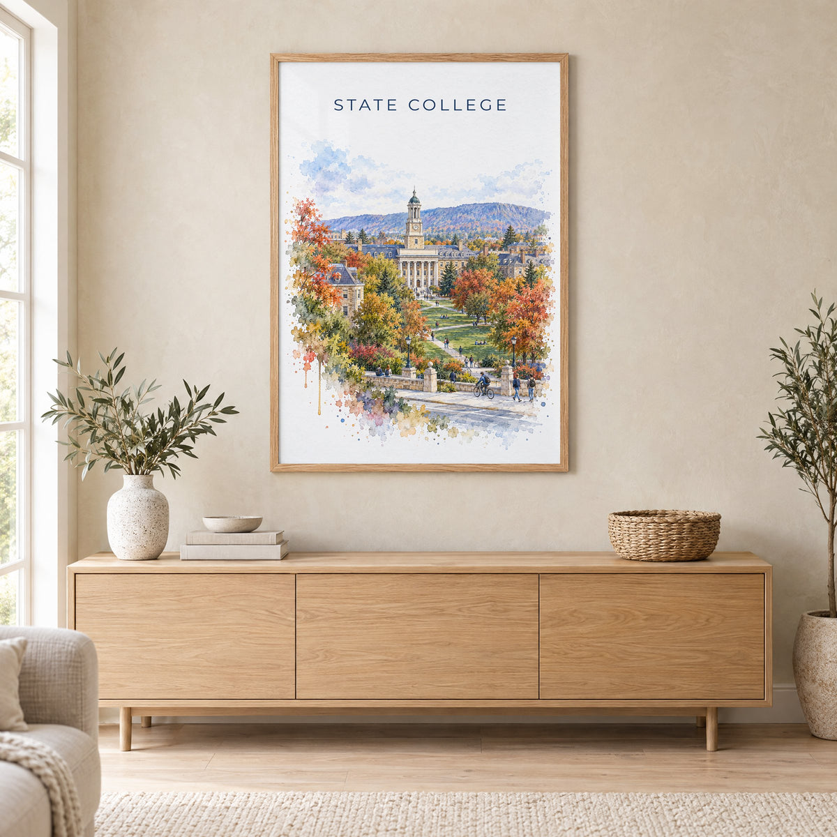 State College watercolor print in an oak frame above a light wood sideboard in a Scandinavian living room