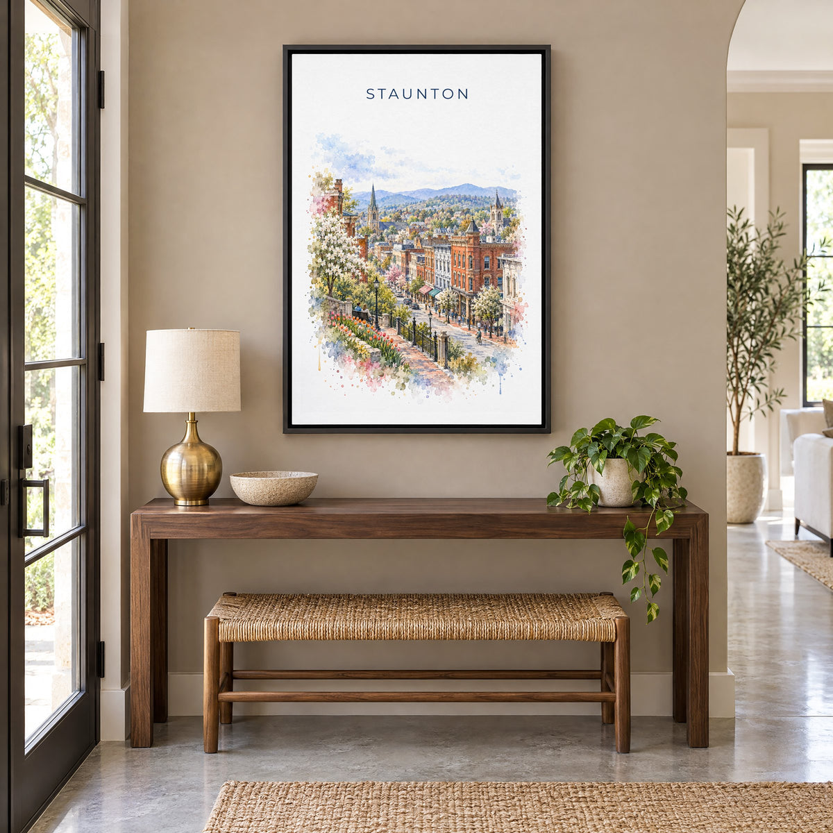 Staunton, Virginia watercolor print as a black floater canvas above a walnut console and woven bench in an entryway