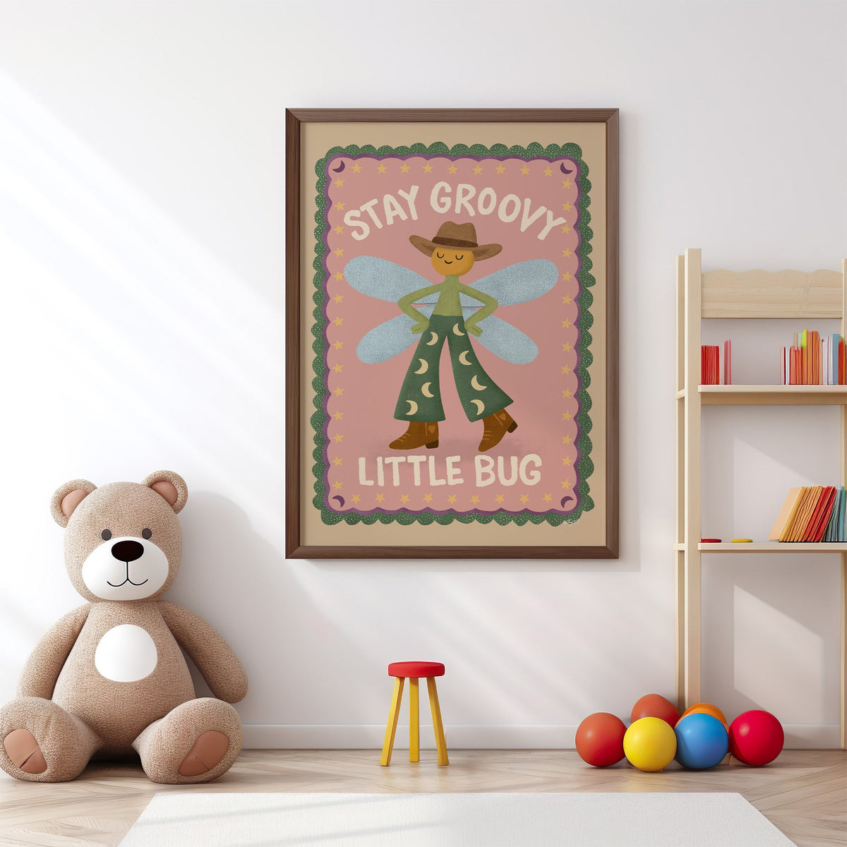 Stay groovy little bug cowboy nursery print in a walnut frame above a big teddy bear by a bookshelf