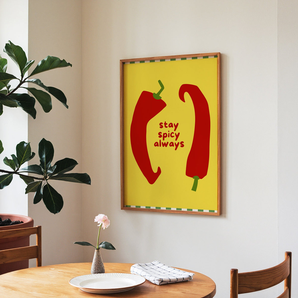 Stay Spicy Always print in a walnut frame above a round table beside a fiddle-leaf fig