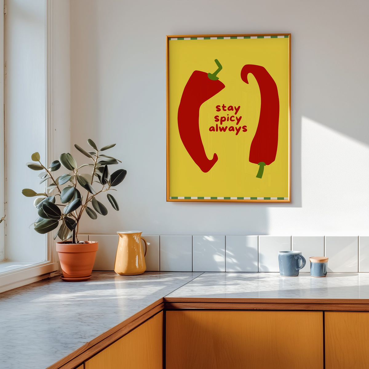 Stay Spicy Always print shown in a gold frame above a marble counter in a tan kitchen