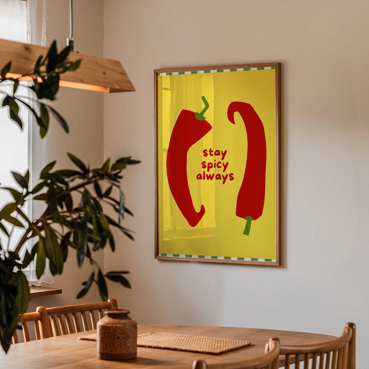 Stay Spicy Always print in a walnut frame above a dining table with olive branches