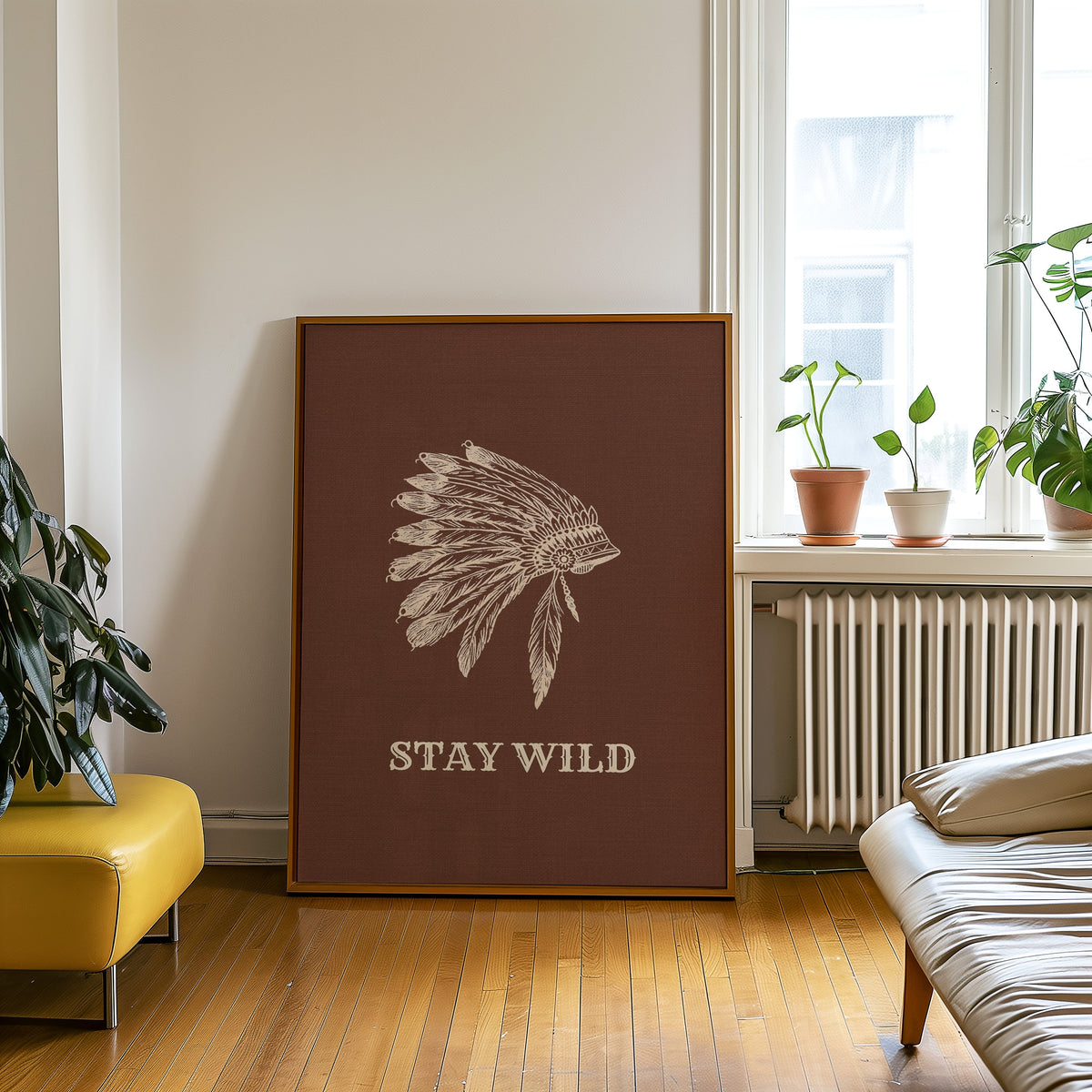 Stay Wild war bonnet brown print in an oak frame on a parquet floor beside a yellow bench