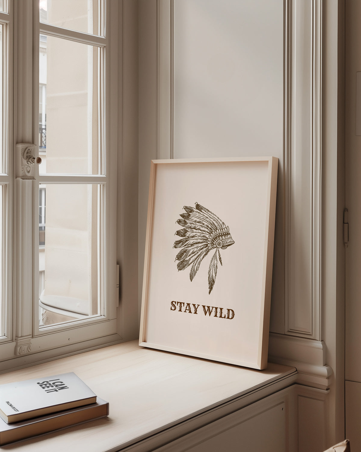 Stay Wild war bonnet cream print in a pale wood frame on a sunlit window ledge