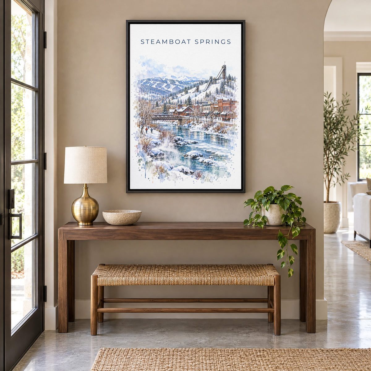 Steamboat Springs watercolor print as a black floater canvas above a walnut console and woven bench in an entryway