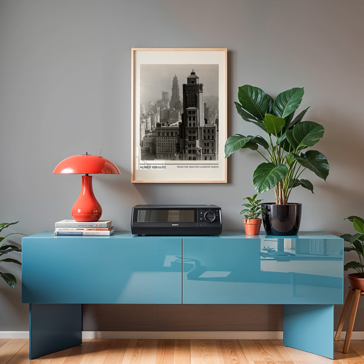 Stieglitz Manhattan print in an oak frame above a teal sideboard with a red lamp