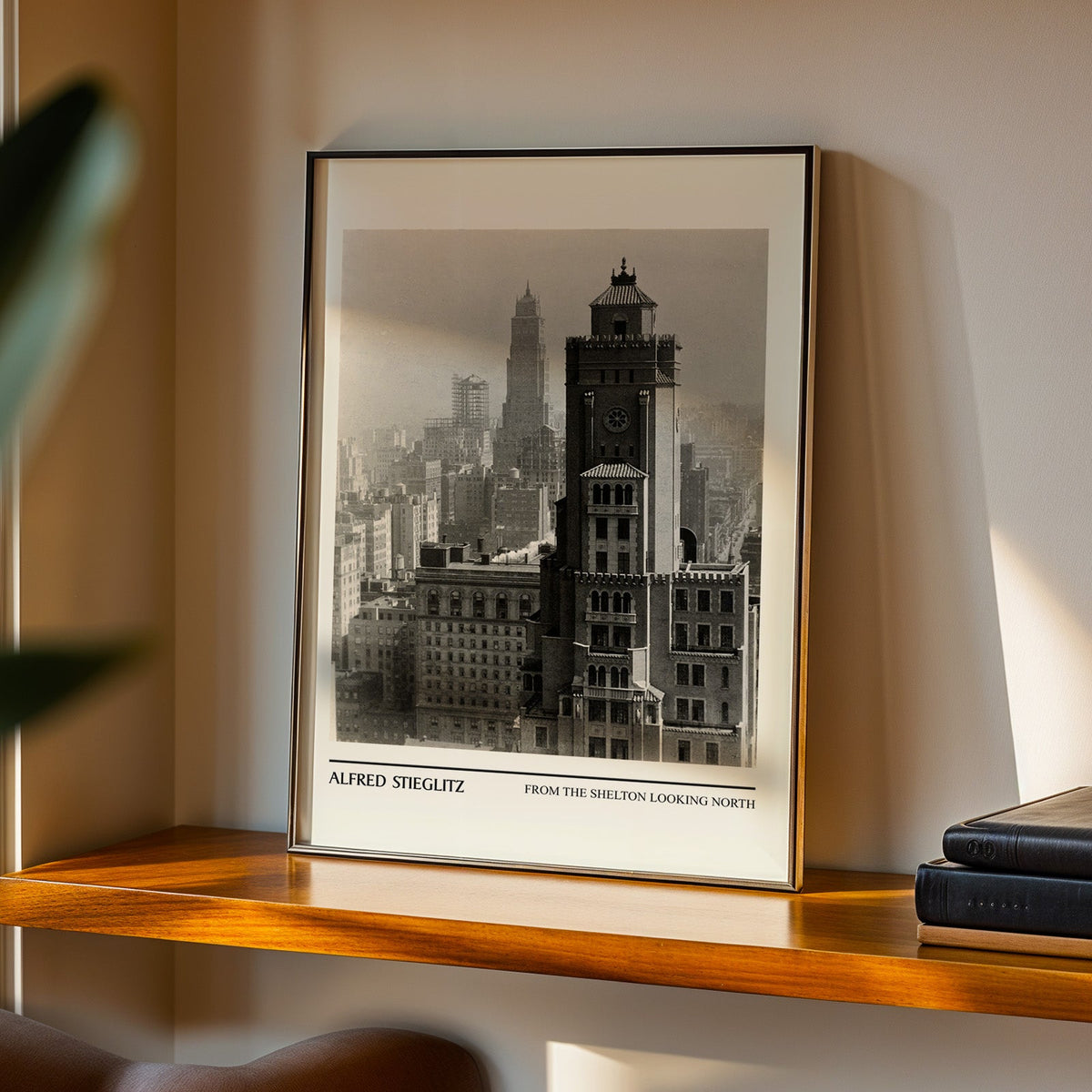 Manhattan tower print in a black frame on a walnut shelf in evening light