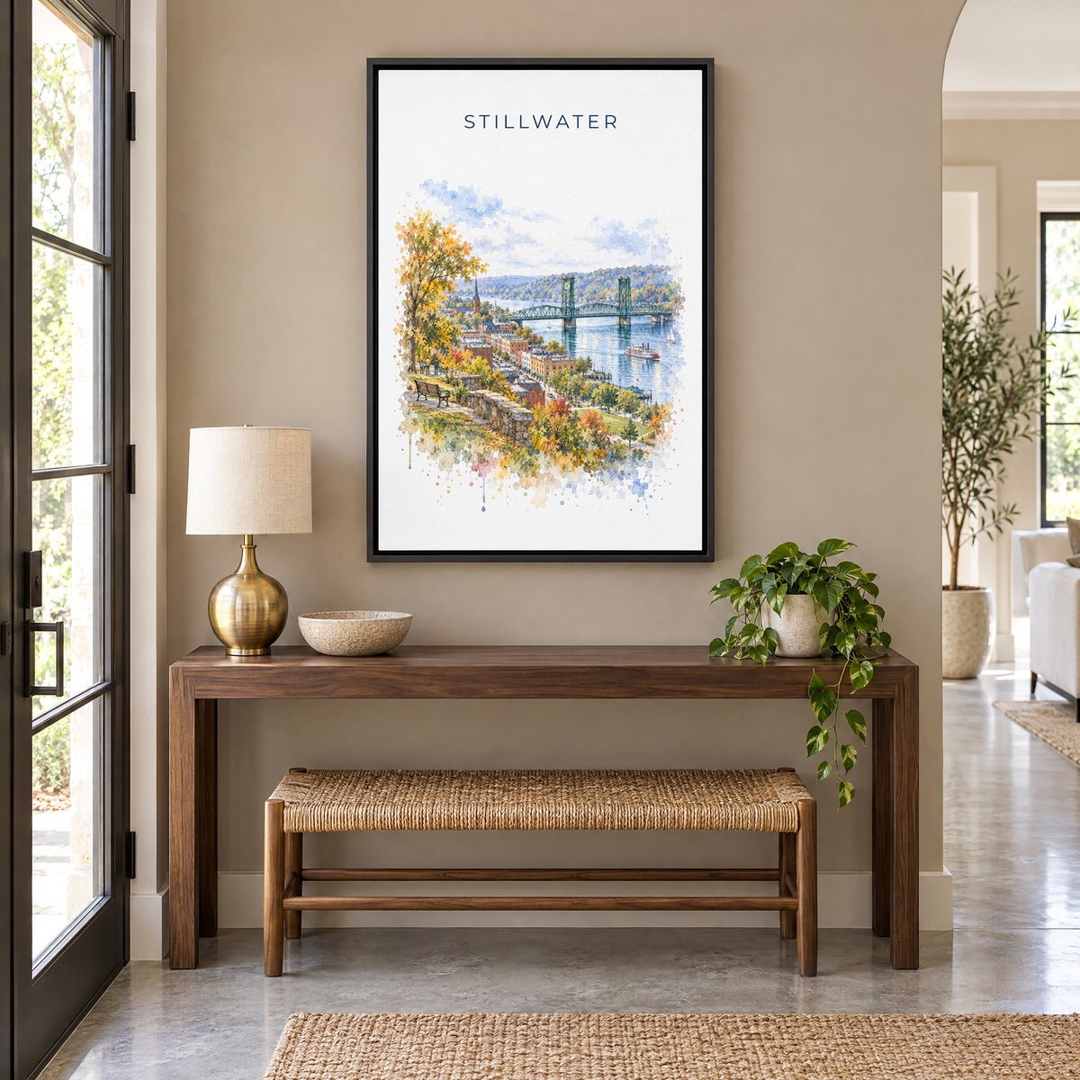 Stillwater, Minnesota watercolor print as a black floater canvas above a walnut console and woven bench in an entryway
