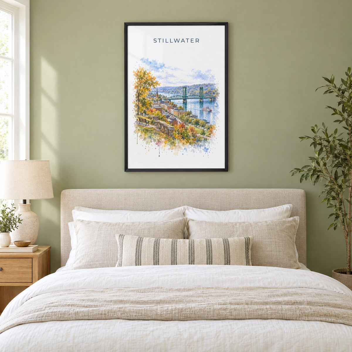 Stillwater, Minnesota watercolor print in a black frame above an upholstered headboard in a sage green bedroom