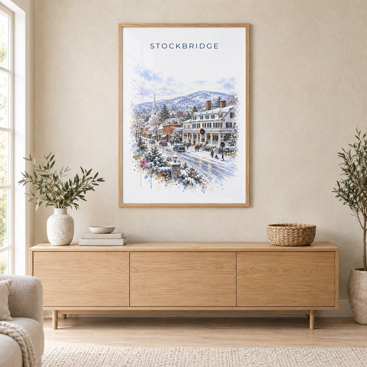 Stockbridge, Massachusetts watercolor print in an oak frame above a light wood sideboard in a Scandinavian living room