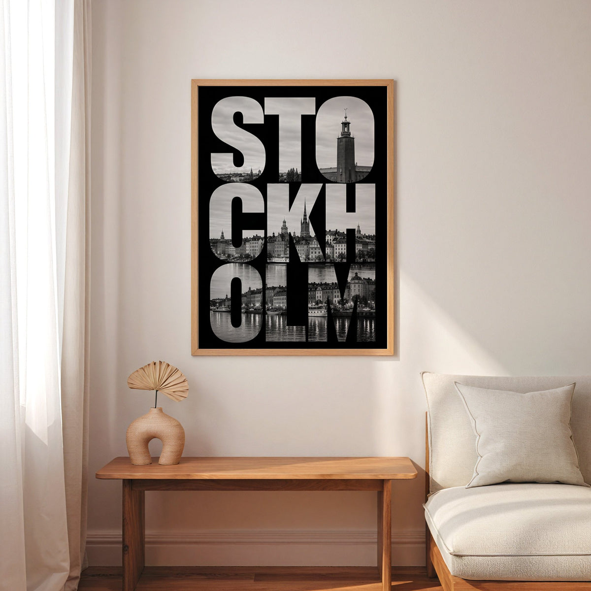 Stockholm letters filled with city photo print in an oak frame above a narrow console with an arched vase