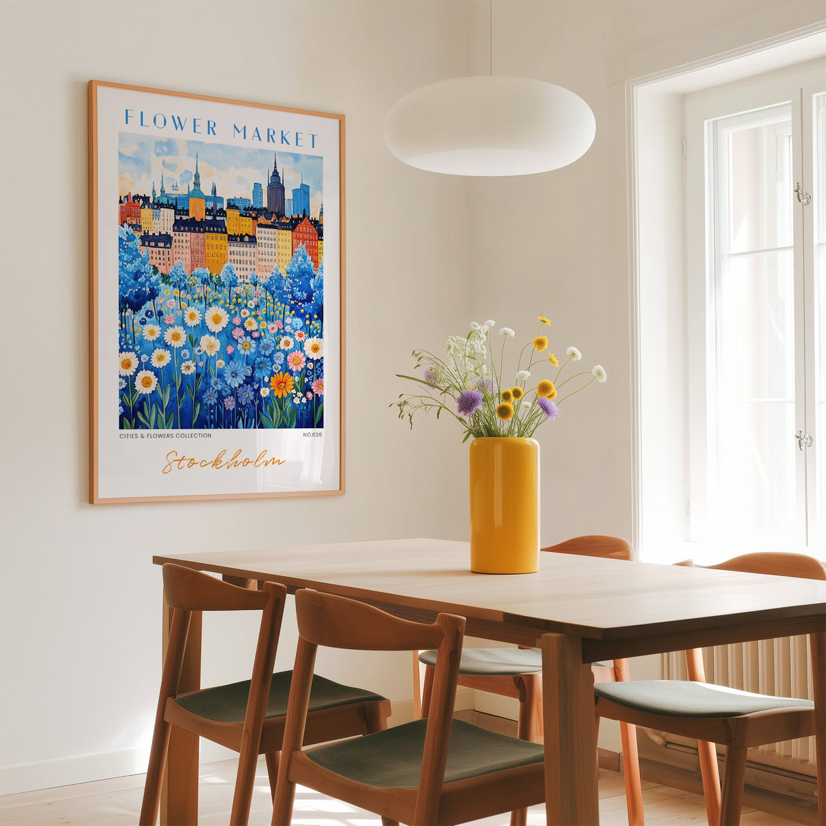 Stockholm flower market print in an oak frame above a dining table with a yellow vase and white pendant light