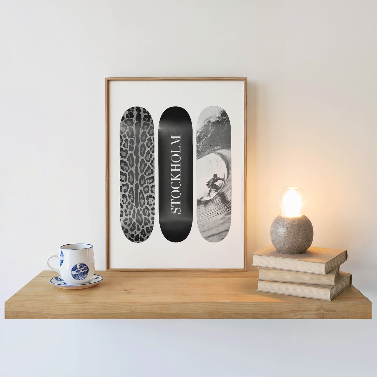 Three skateboards with leopard spots, Stockholm deck, surfer in an oak frame on a floating shelf beside a glowing lamp