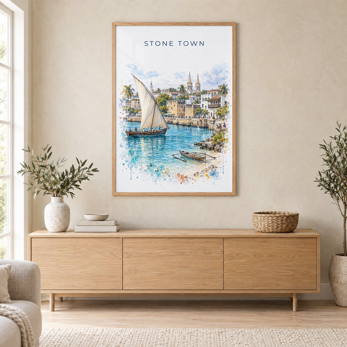 Stone Town watercolor print in an oak frame above a light wood sideboard in a Scandinavian living room