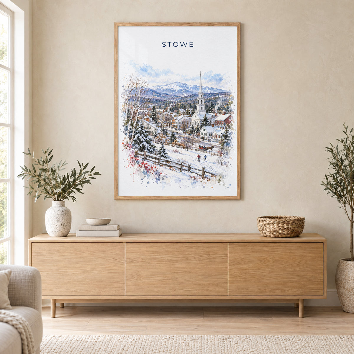 Stowe, Vermont watercolor print in an oak frame above a light wood sideboard in a Scandinavian living room