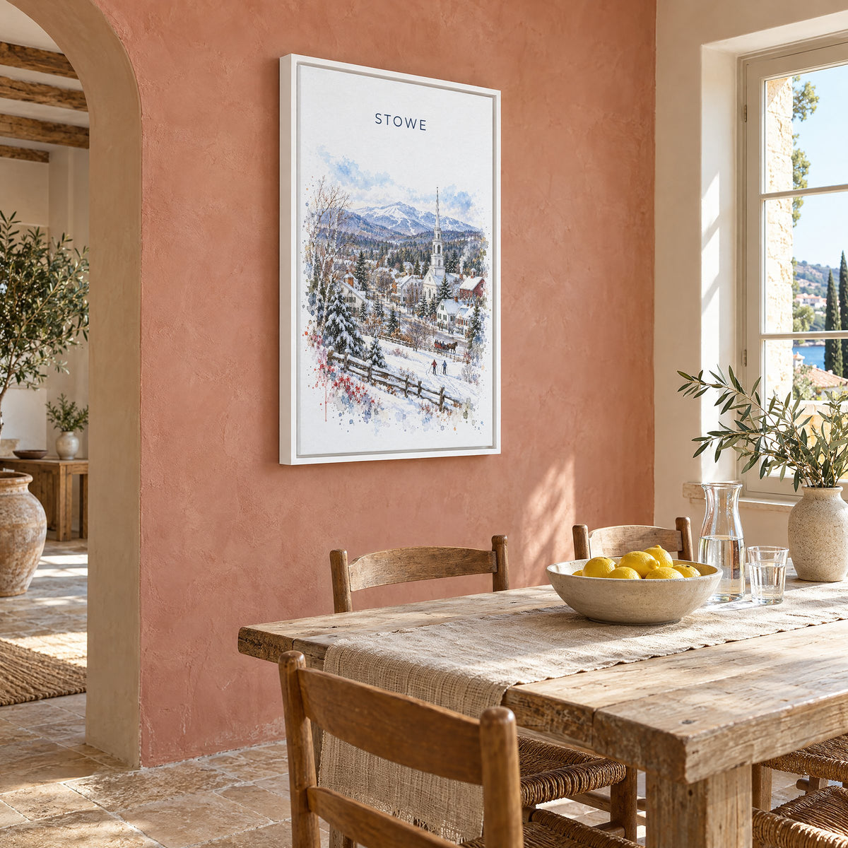 Stowe, Vermont watercolor print as a white floater canvas on a terracotta wall above a rustic dining table